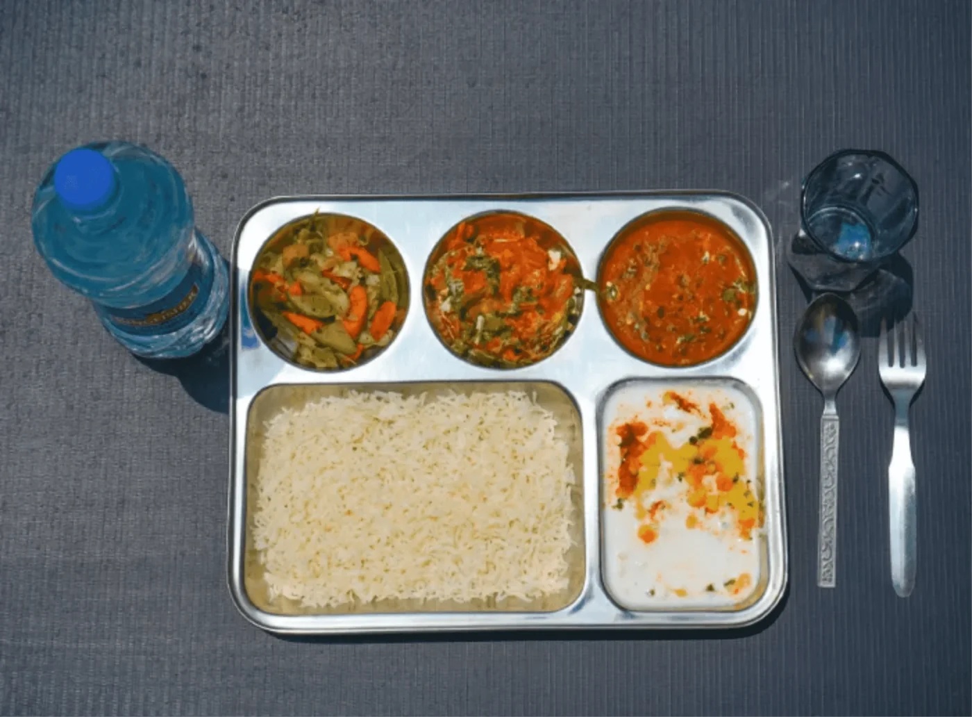 Colorful vegetarian thali with fresh vegetables, rice, and dal.